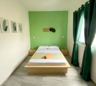 a bed in a room with green walls and curtains at Sal Rei Apartments, Boa Vista in Sal Rei