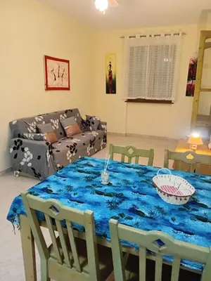 a living room with a blue table with chairs and a couch at Sal Rei Apartments, Boa Vista in Sal Rei