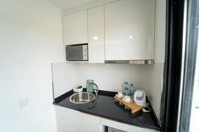 a small kitchen with white cabinets and a sink at GREEN STUDIO TARRAFAL - Ap 01 in Prainha