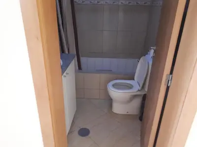 a bathroom with a white toilet in a room at Avenida NHU SANTIAGO in Santa Cruz