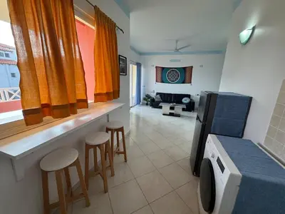 a living room with a counter and stools in a room at Holiday Properties Ocean Breeze in Santa Maria