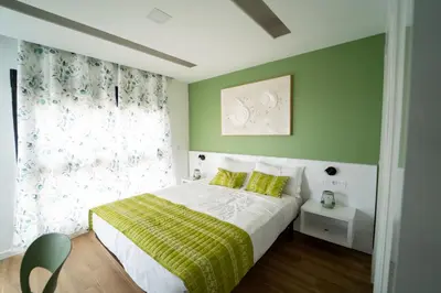 a bedroom with a bed with green walls and a window at GREEN STUDIO TARRAFAL - Ap 03 in Tarrafal