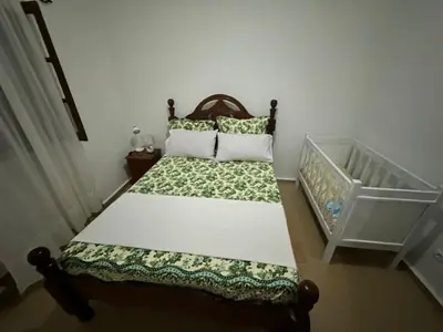 a bed in a room with a crib at Kasa Kutxa in Tarrafal