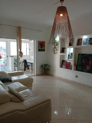 a living room with a couch and a chandelier at Four Palms Guest House in Praia