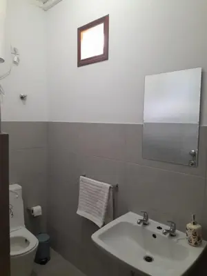 a bathroom with a sink and a toilet and a mirror at Mindelo Tamba in Mindelo