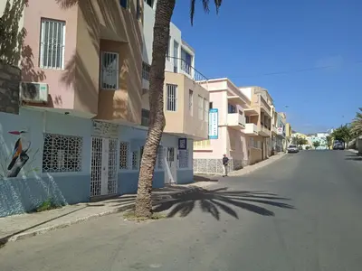 a palm tree on the side of a street with buildings at Mindelo Tamba in Mindelo