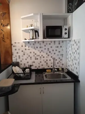 a kitchen with a sink and a microwave at Mindelo Tamba in Mindelo