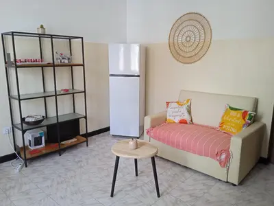 a living room with a couch and a table and a refrigerator at Mindelo Tamba in Mindelo