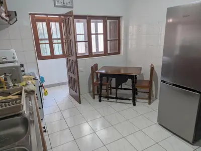 a kitchen with a table and a refrigerator at Cozy 3 Bdr at Praia Da Laginha in Mindelo