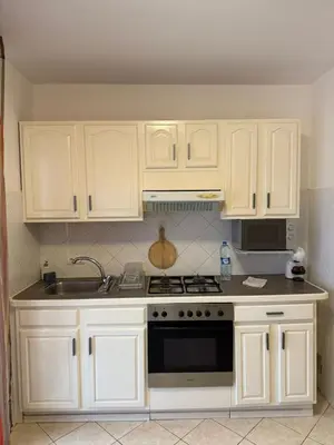 a kitchen with white cabinets and a stove top oven at Murdeira V162 A by RPG Group in Beirona