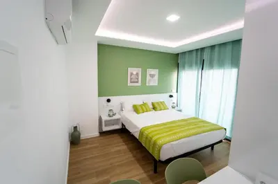 a bedroom with a bed with a green wall at GREEN STUDIO TARRAFAL - Ap 04 in Tarrafal