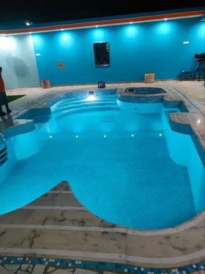 a large pool with blue water in a building at Residencial oliveira in Porto Novo