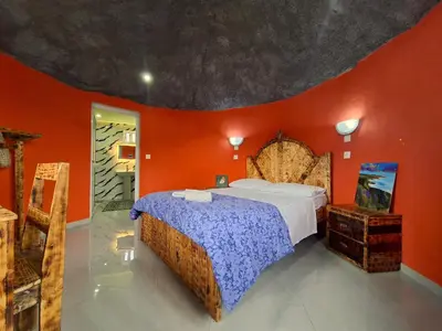 a bedroom with a bed and an orange wall at Funco Du Santos in Portela