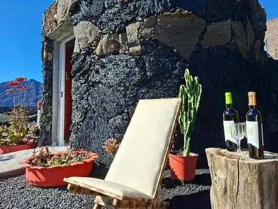 a chair and two bottles of wine next to a wall at Funco Du Santos in Portela