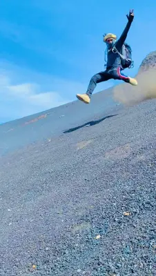 a person is jumping in the air on a beach at Funco Du Santos in Portela