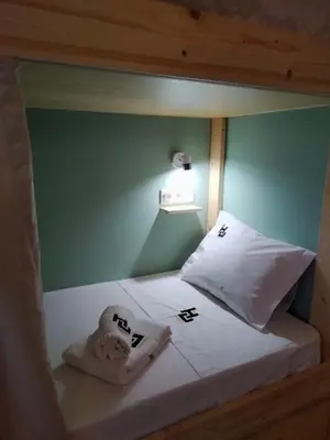 a bed in a room with a green wall at Urban Hostel Mindelo in Mindelo