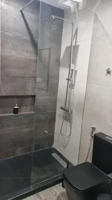 a bathroom with a glass shower with a toilet at Casa Morada in Mindelo
