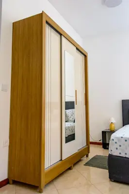 a bedroom with a large wooden cabinet with a mirror at Mindelo Dias in Mindelo