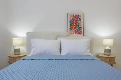 a bedroom with a blue bed with two lamps at Marel Bliss Apartments T3 - Isabel in Mindelo