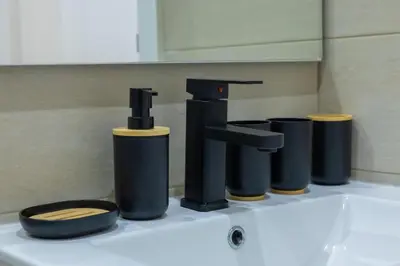 a bathroom sink with a faucet and four trash cans at Marel Bliss Apartments T3 - Isabel in Mindelo
