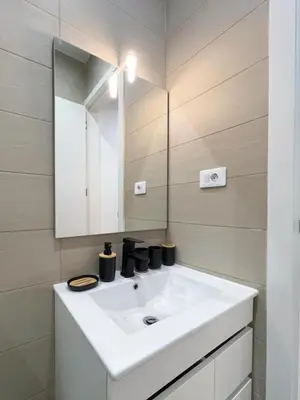 a bathroom with a white sink and a mirror at Marel Bliss Apartments T3 - Isabel in Mindelo