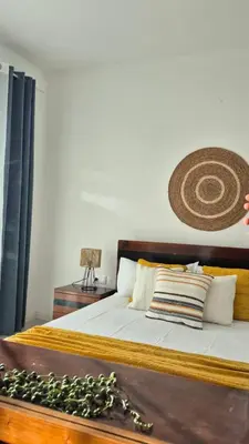 a bedroom with a bed with a wooden headboard at kriola Breeze in Praia