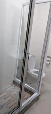 a bathroom with a toilet through a glass window at Edly aparatments in Mindelo