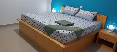 a bedroom with a bed with a wooden frame at Edly aparatments in Mindelo