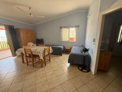 a living room with a table and a bed at A Casa do Amor in Vila do Maio