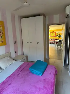 a bedroom with a large bed with a purple blanket at Brisa Meridiana in Santa Maria