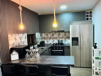 a kitchen with a stainless steel refrigerator and black cabinets at Tropical Nest in Espargos