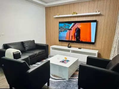 a living room with black furniture and a flat screen tv at Tropical Nest in Espargos