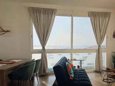 a living room with a blue couch and a large window at The Blue Haven in Sal Rei