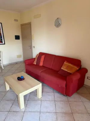 a red couch in a living room with a coffee table at Seaside apartment in Shell Beach in Santa Maria