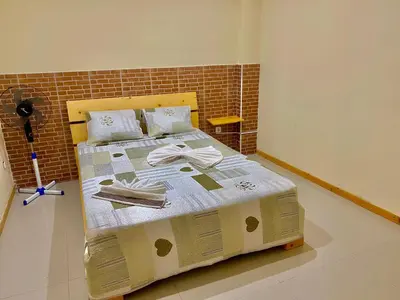 a bed in a room with a brick wall at Pensão Twins Carioca in Tarrafal
