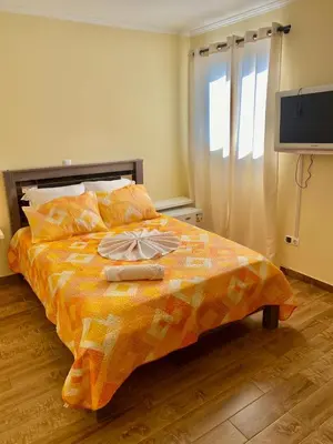 a bedroom with a bed with two towels on it at Pensão Twins Carioca in Tarrafal