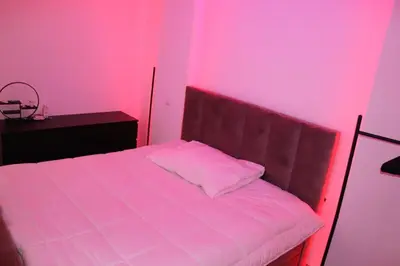 a bedroom with a bed with pink lights on it at Micaya in Praia