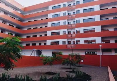 an apartment building with trees in front of it at Micaya in Praia