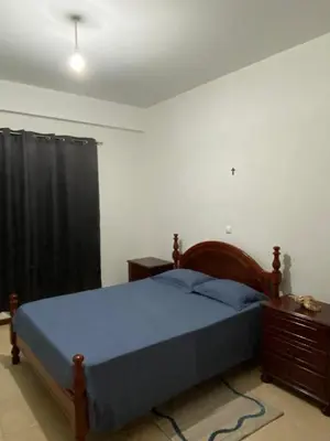 a bedroom with a bed with a blue comforter at Mindelo Family Apartment in Mindelo