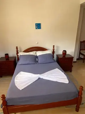 a bedroom with a bed with a bow tie on it at Mindelo Family Apartment in Mindelo