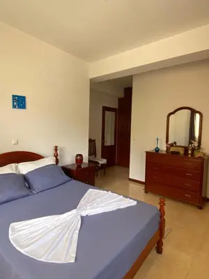 a bedroom with a bed and a dresser and a mirror at Mindelo Family Apartment in Mindelo