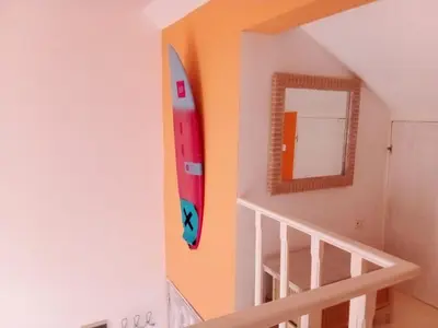 a surfboard hanging on a wall next to a staircase at Holiday Properties Vista Do Mar - Wi-fi in Santa Maria