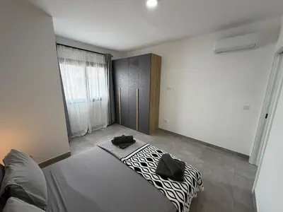 a bedroom with a bed with black and white sheets at Praça Presidente - By Bobbywashere in Santa Maria
