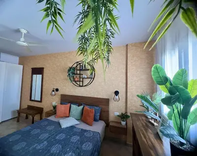 a bedroom with a bed and some plants at Tropical Palma in Santa Maria