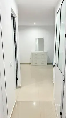 a white room with a dresser and a white floor at Morabeza Home in Praia