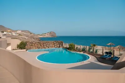 a swimming pool with the ocean in the background at Las Rochas Mindelo Aparthotel in Mindelo