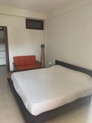 a bedroom with a large bed and a chair at Shay's House in Mindelo in Mindelo