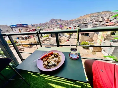 a plate of food on a table with a glass of water at Shared Room with Balcony in Praia 5 Minute Walk to Beach in Praia