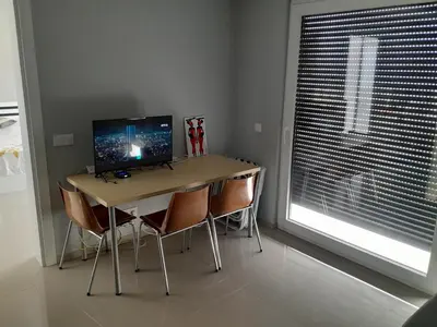 a desk with a computer on it in a room with a window at VISTA INVEST Apartamentos in Mindelo