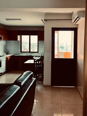 a living room with a black door and a kitchen at Ferreira e Brito apartamentos in Espargos